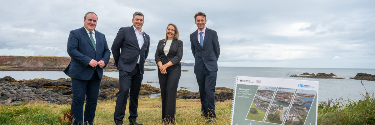 four people stand alongside Eyemouth Harbour Masterplan document